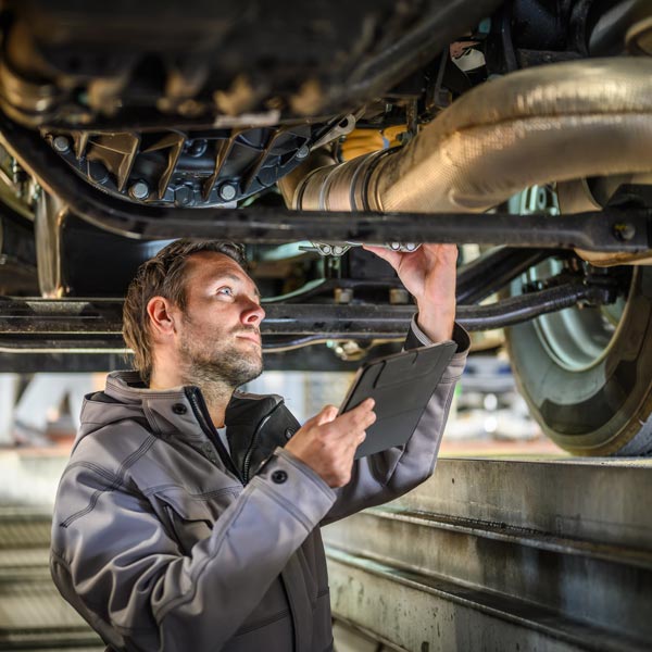 mechanic inspecting car underbody