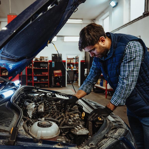 mechanic inspecting car under the hood