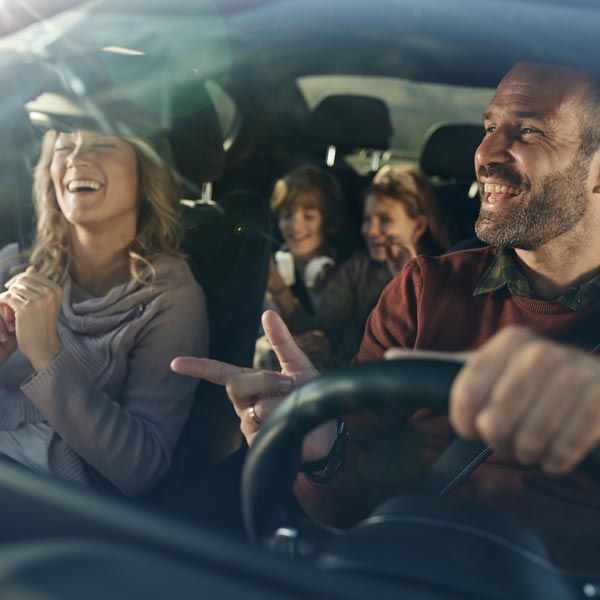 family laughing and driving in car